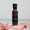 Flasche mit basque pork garum umgeben von Schinkenscheiben, handgefertigt und natürlich fermentiert in Berlin.