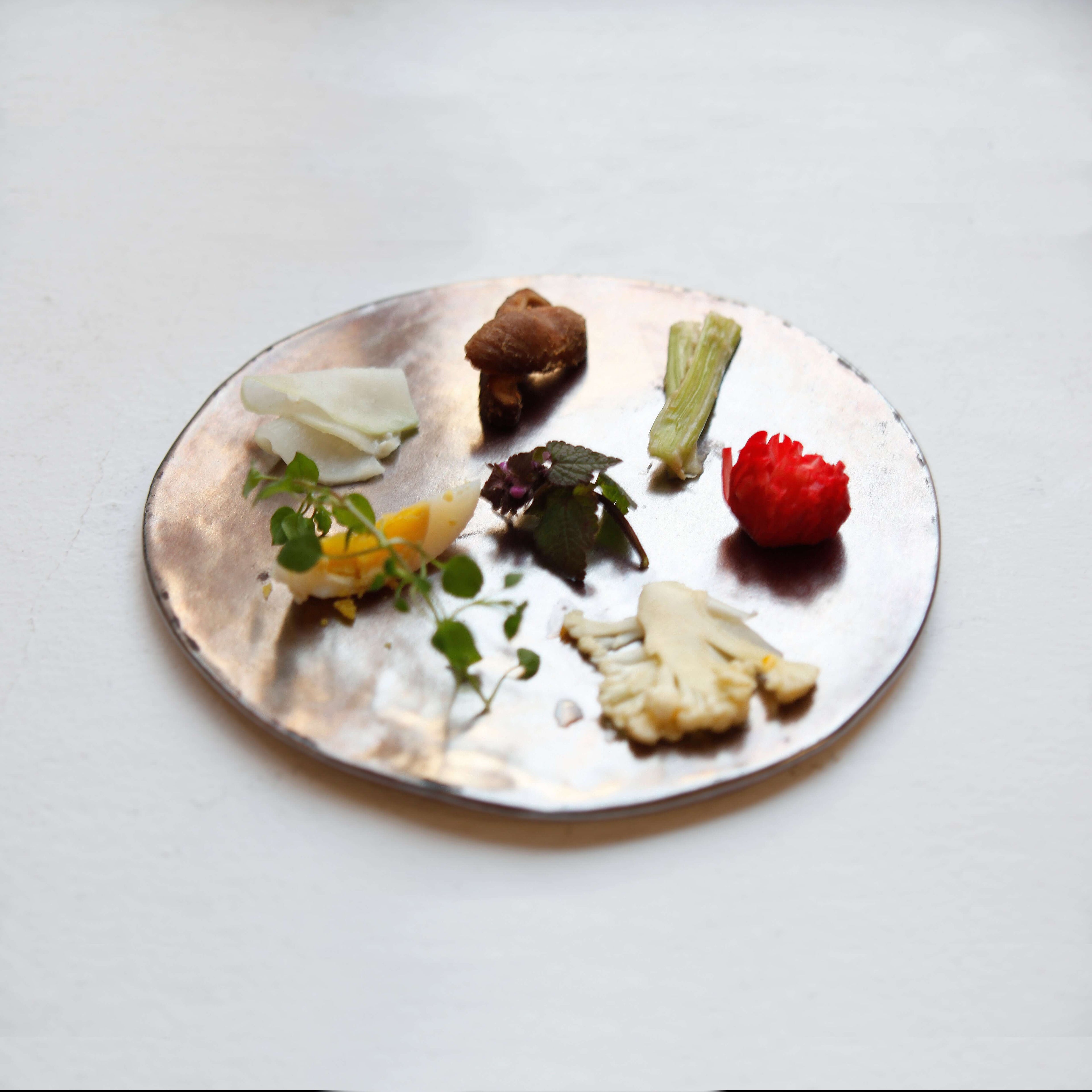 moon Teller - eine silberne Platte mit frischen Kräutern und Gemüse.